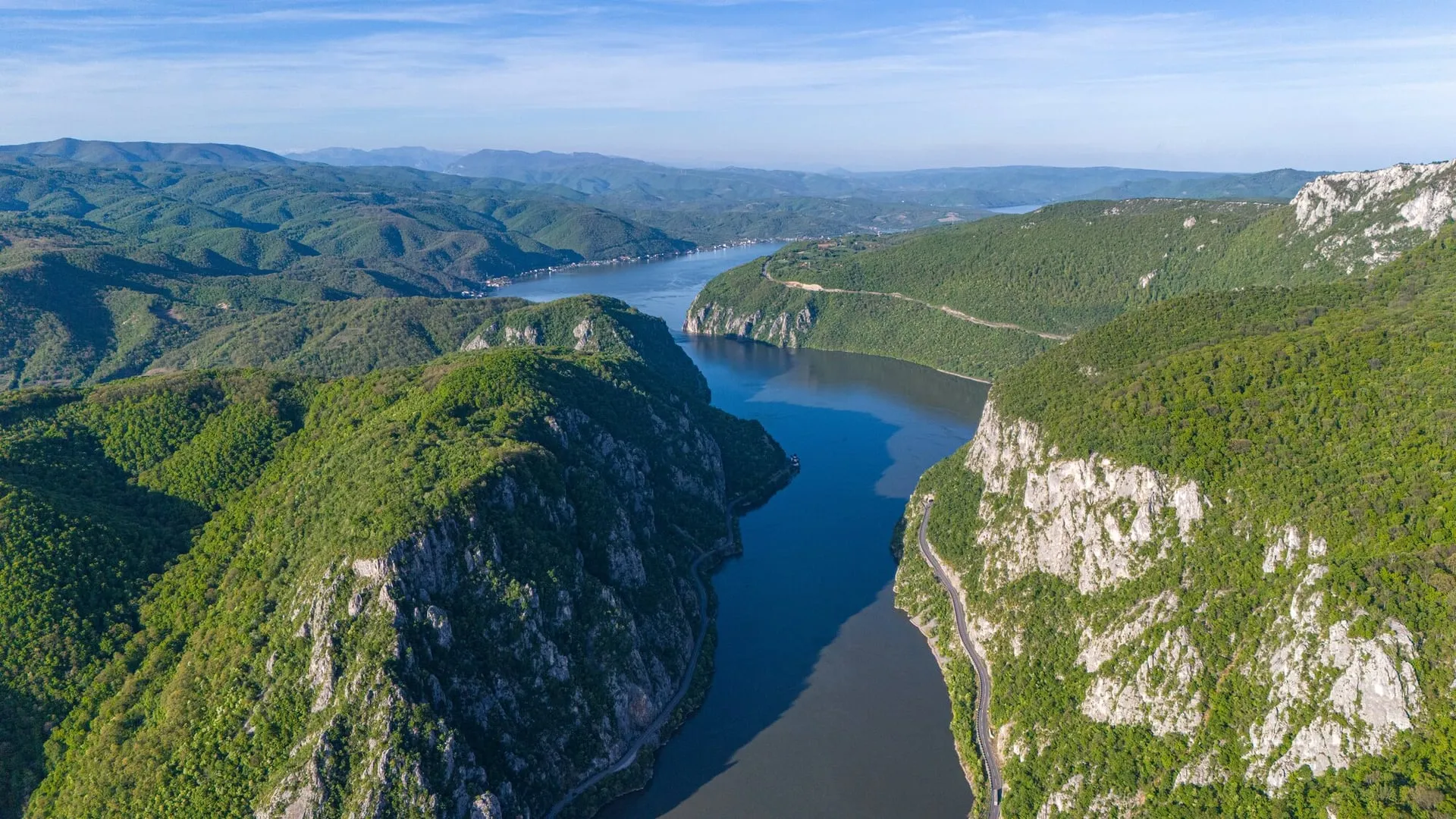 Aerial view of the Danube winding through the forested limestone cliffs of the Iron Gates gorge on the Serbia–Romania border