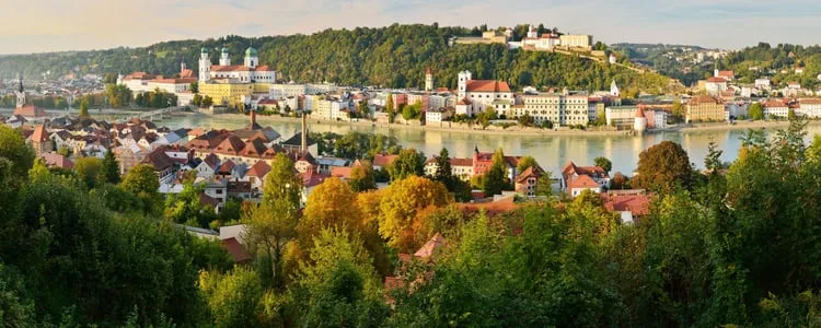 Passau, Germany, with its baroque cathedral towers rising above the riverside old town amid autumn colour, on Avalon Waterways' Magnificent Rivers of Europe cruise route