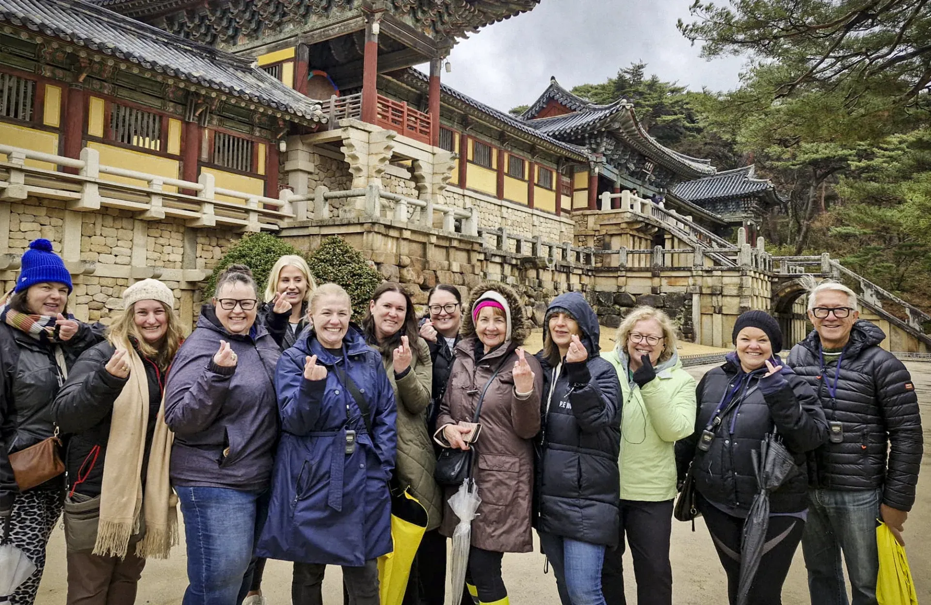 A Bunnik Tours small group making finger hearts in front of Bulguksa Temple in South Korea