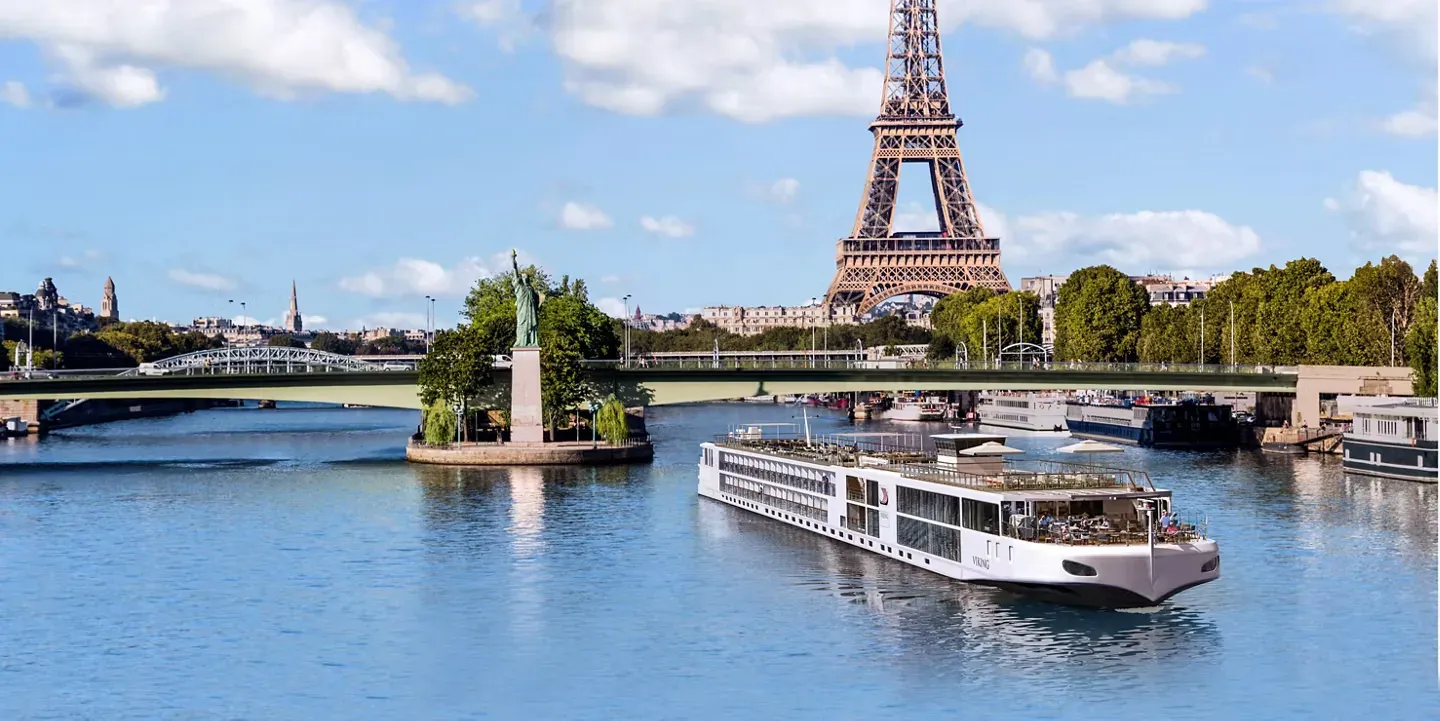 A Viking Longship on the Seine in Paris, passing the Statue of Liberty replica with the Eiffel Tower behind